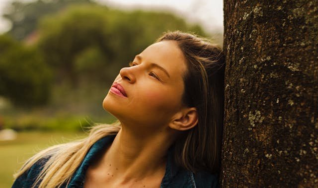 woman leaning on tree, choosing how to relate